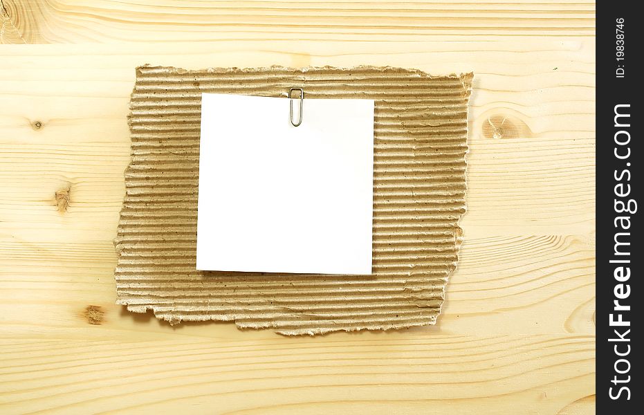 White blank on ripped cardboard on wooden