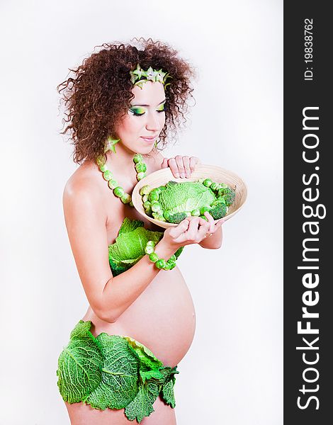 Beautiful pregnant young woman dressed in cabbage isolated on white