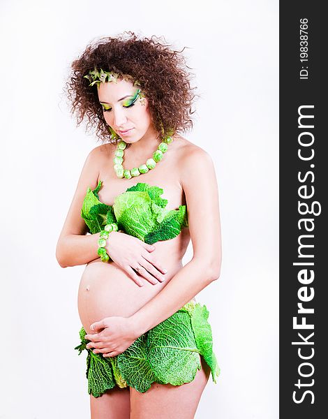 Beautiful pregnant young woman dressed in cabbage isolated on white