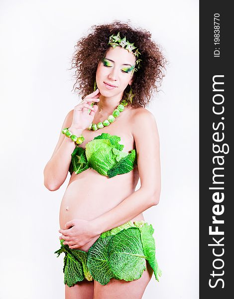 Beautiful pregnant young woman dressed in cabbage isolated on white