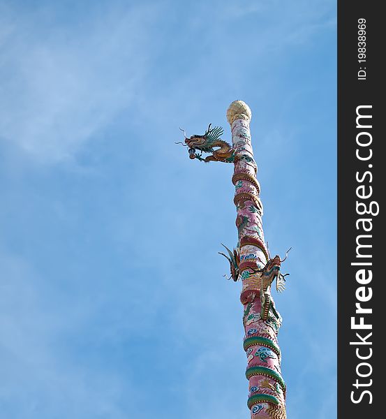 Chinese dragon pillars with blue sky on background.