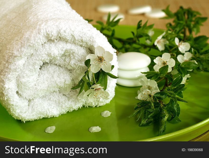 Spa composition of towel, stones and spring branch with flowers. Spa composition of towel, stones and spring branch with flowers