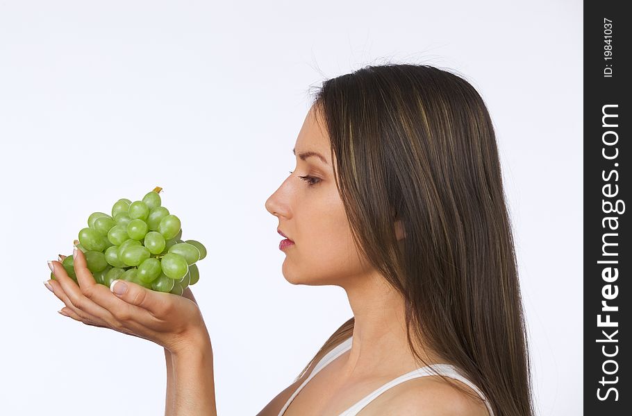 Young woman looking at fresh grapes in her hands. Young woman looking at fresh grapes in her hands