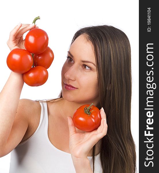 Young woman looking at fresh tomatoes in her hand. Young woman looking at fresh tomatoes in her hand