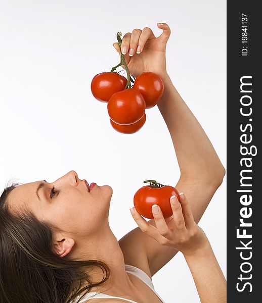 Young woman looking at tomatoes in her hand. Young woman looking at tomatoes in her hand