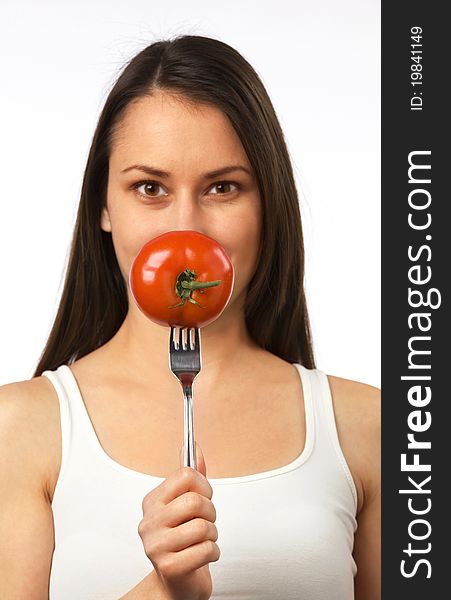 Young woman holding fresh tomato on fork. Young woman holding fresh tomato on fork