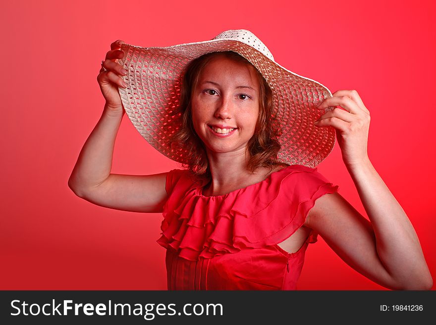 Adorable woman in beautiful red dress and summer hat. Portrait on a red background. Adorable woman in beautiful red dress and summer hat. Portrait on a red background.