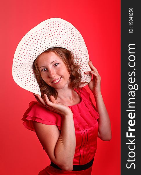 Adorable woman in beautiful red dress and summer hat. Portrait on a red background. Adorable woman in beautiful red dress and summer hat. Portrait on a red background.