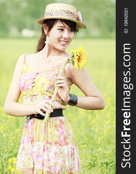 Asian girl holding the sunflower in summer field. Asian girl holding the sunflower in summer field.