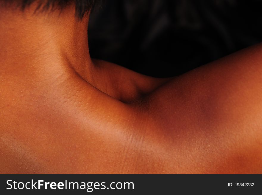 An over the shoulder, abstract shot of a black / African-American woman's neck and shoulder with brilliant copper & mahogany tones. An over the shoulder, abstract shot of a black / African-American woman's neck and shoulder with brilliant copper & mahogany tones.