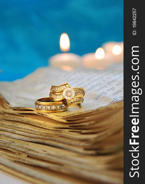 Wedding rings on a book with teal background