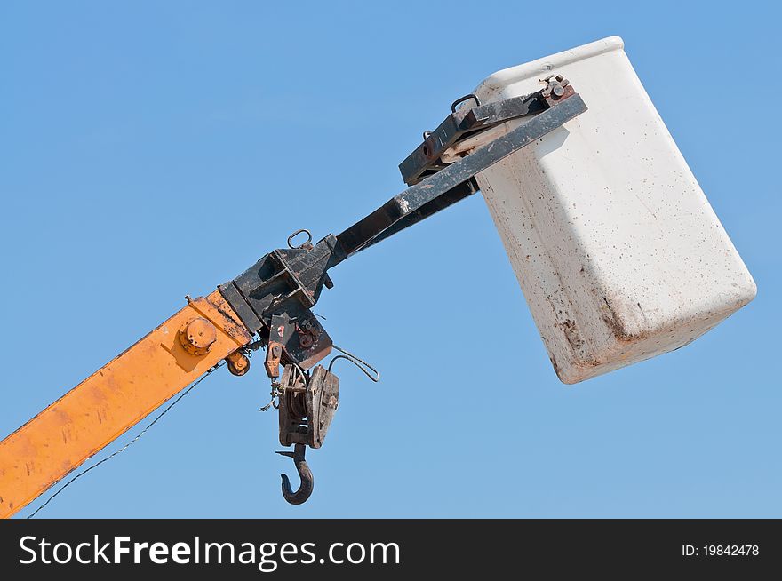 Top part of a heavy crane against a blue sky.