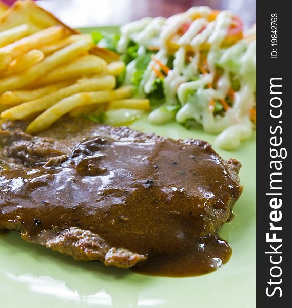 Steak with fresh vegetables salad and french fries