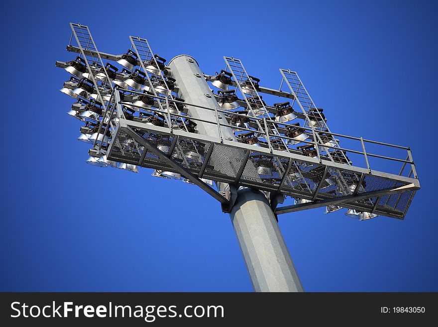 Rows of stadium lights against a blue sky