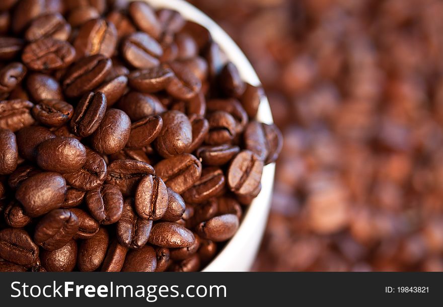A close-up image of coffee beans in a coffee cup and its surroundings.