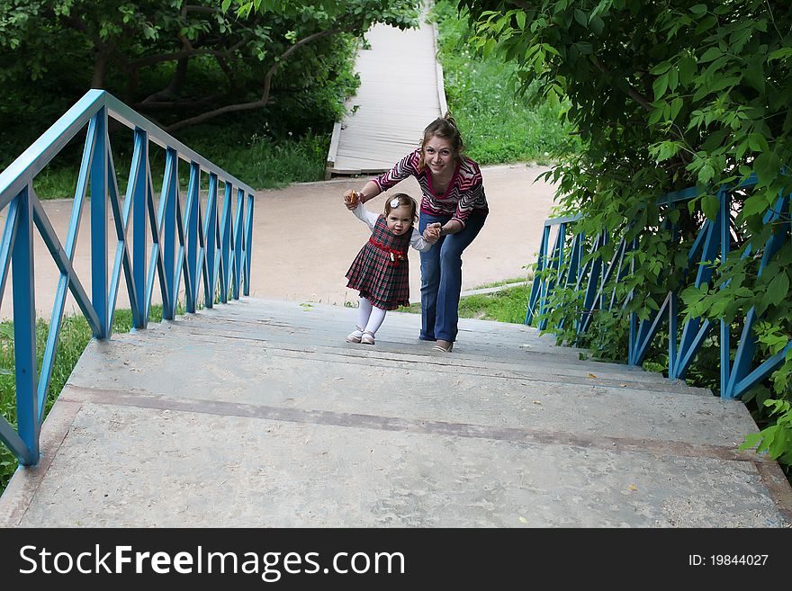 Mother and her little daughter on park staircase. Mother and her little daughter on park staircase.