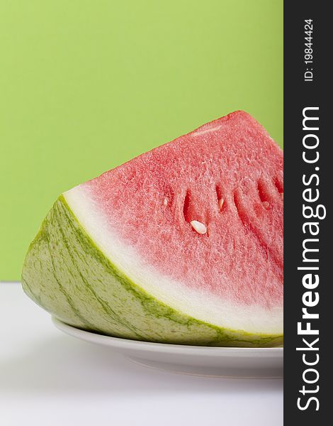 Studio-shot of a plate with fresh piece of watermelon, on a green background. Studio-shot of a plate with fresh piece of watermelon, on a green background