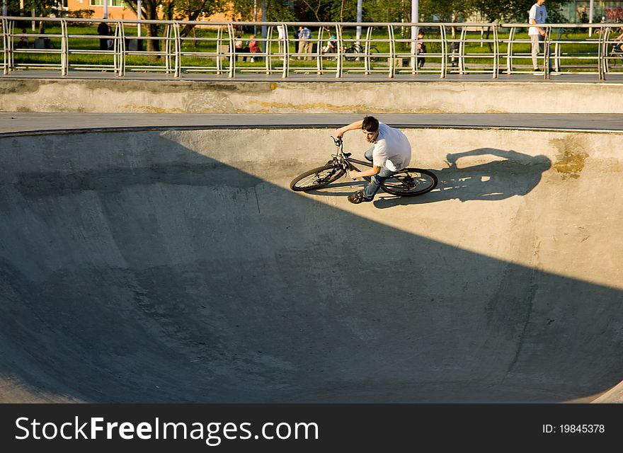 A cyclist rides his bike on the extreme park, doing a turn. A cyclist rides his bike on the extreme park, doing a turn.