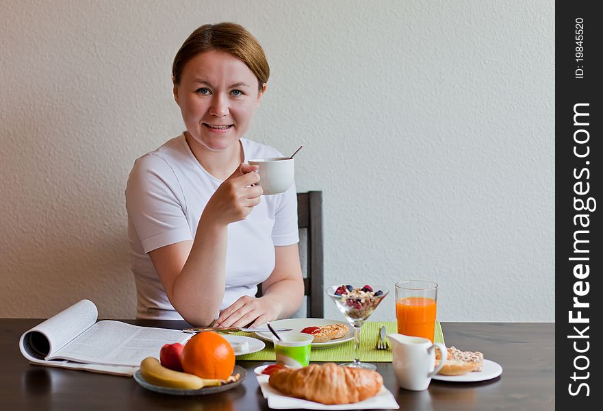 Woman drinking coffe while having her breakfast. Woman drinking coffe while having her breakfast