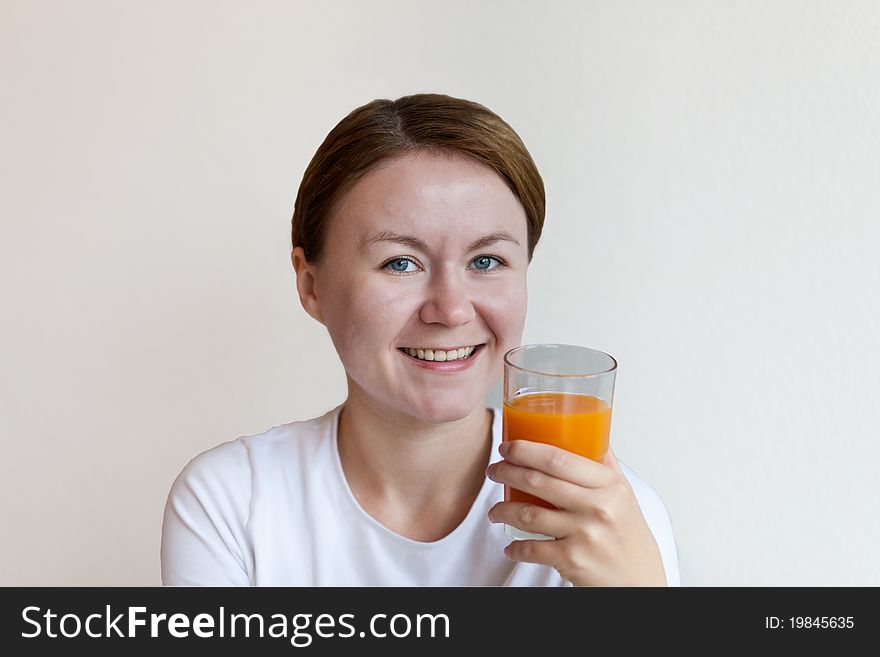 Woman holding a glass of orange juice and smiling