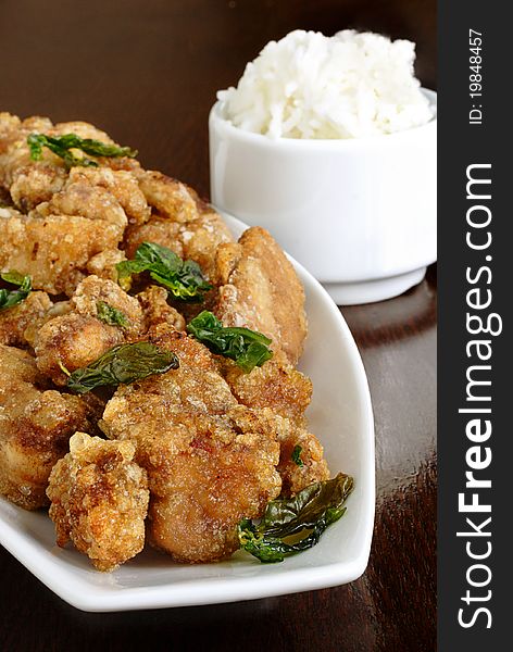 Thai deep fried chicken and basil served with a side of white rice. Thai deep fried chicken and basil served with a side of white rice