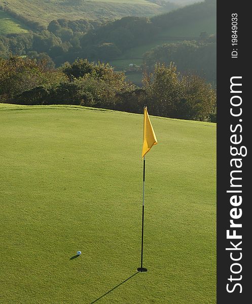 Golf ball near the hole on a beautiful course. Golf ball near the hole on a beautiful course