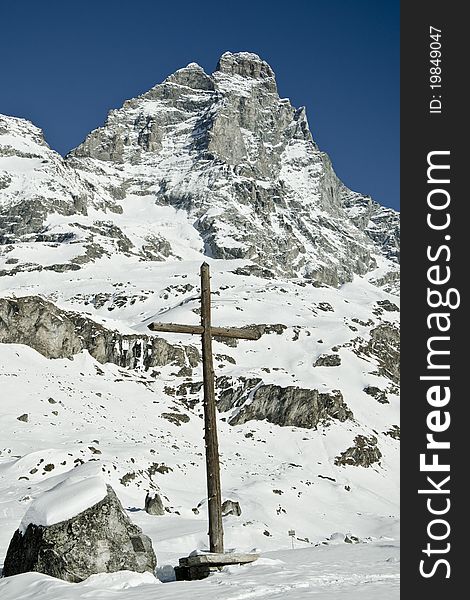 Cross under italian famous mountain Cervino surrounded by snow. Cross under italian famous mountain Cervino surrounded by snow