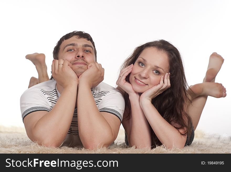 Nice young couple lying on a carpet. Nice young couple lying on a carpet