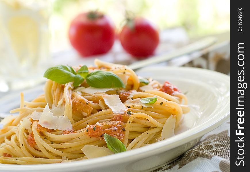 Spaghetti with a tomato sauce, cheese and a basil. Selective focus