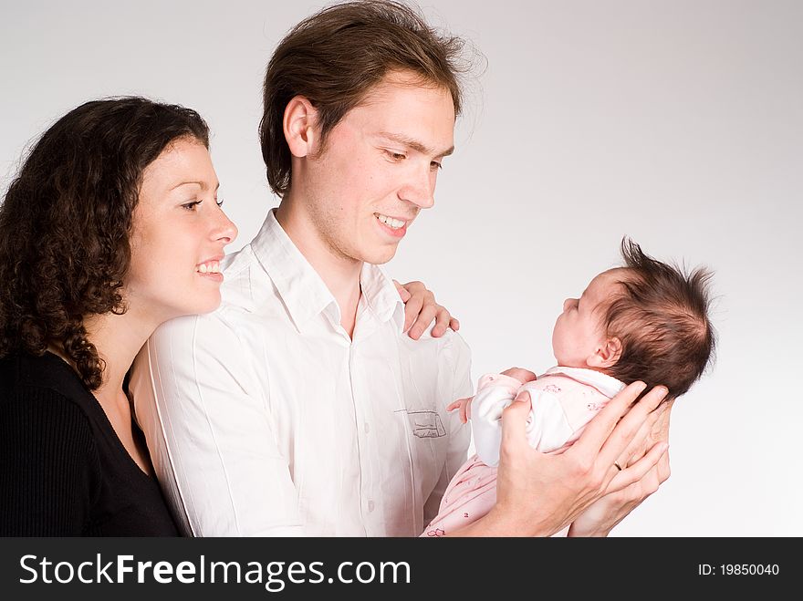 Happy young family with newborn on a white. Happy young family with newborn on a white