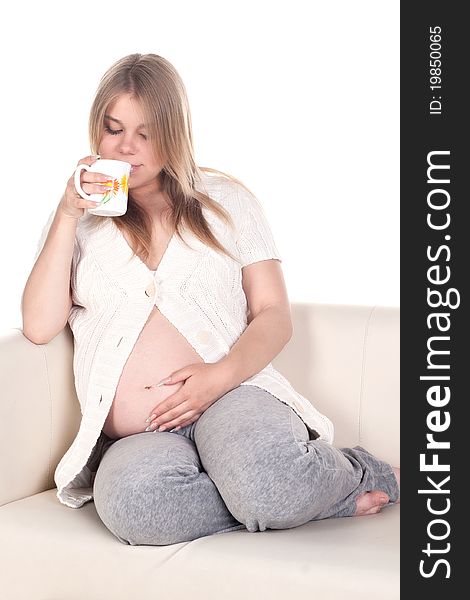 Pregnant woman sitting and drinking tea