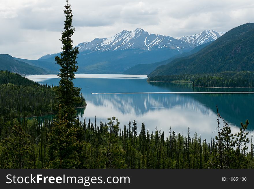 A boat crosses the jade coloured Lake Mucho in northern British Columbia, Canada. A boat crosses the jade coloured Lake Mucho in northern British Columbia, Canada.