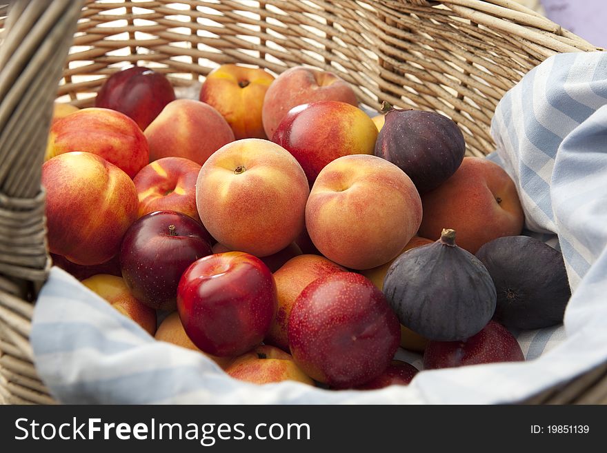 Different varieties of tropical fruits arranged in a picnic basket. Different varieties of tropical fruits arranged in a picnic basket