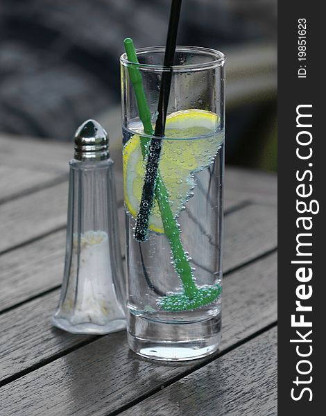 A glass with sparkling water and a lemon inside. A glass with sparkling water and a lemon inside.