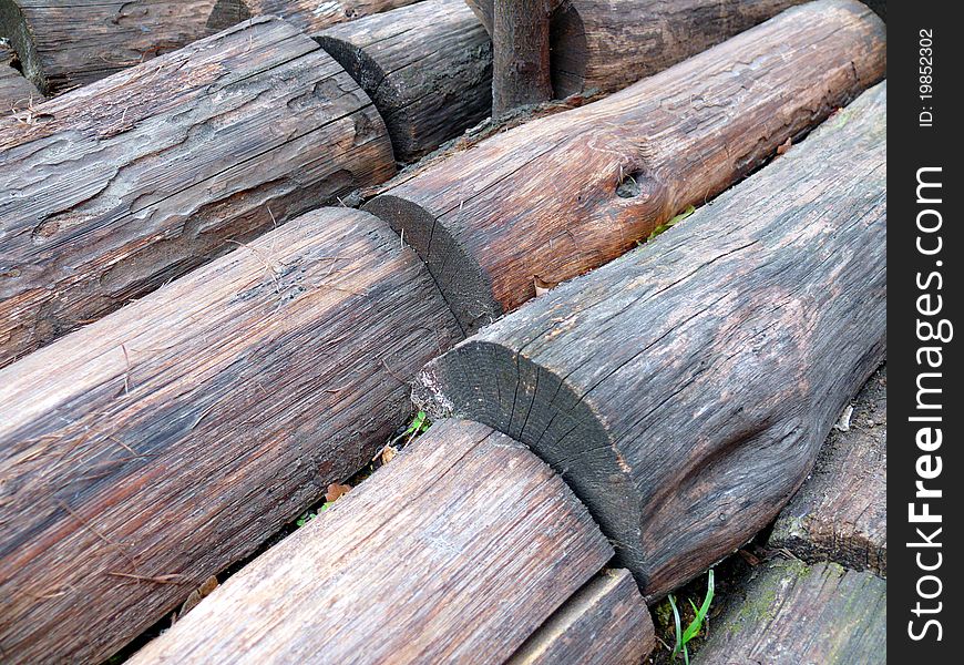 Background - Rows of rough brown wood trunks