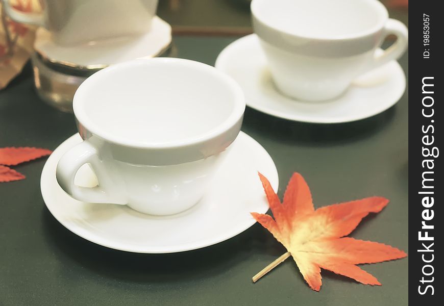 Tea cup and maple leaf on table