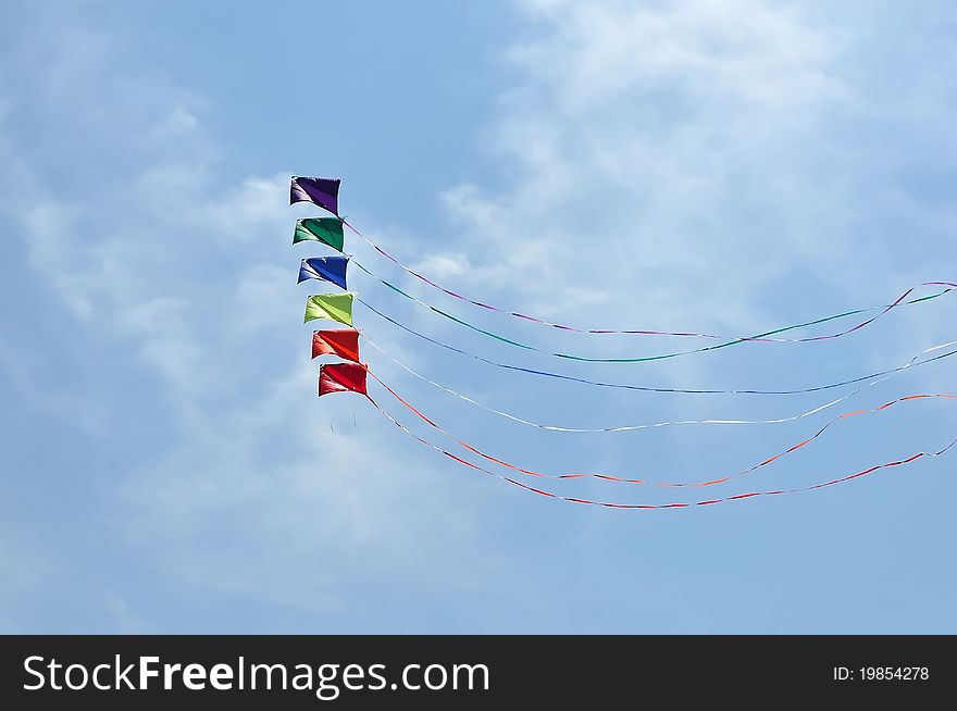 Colorful kite soaring against blue sky. Summer Kite Festival. Colorful kite soaring against blue sky. Summer Kite Festival