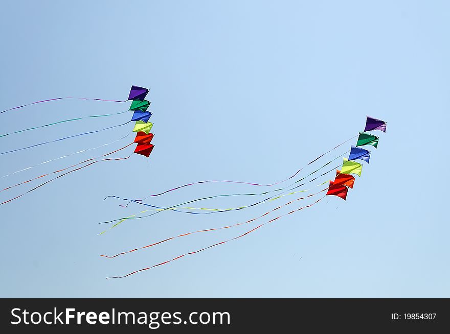 Colorful kite flying against blue sky. Summer Kite Festival. Colorful kite flying against blue sky. Summer Kite Festival