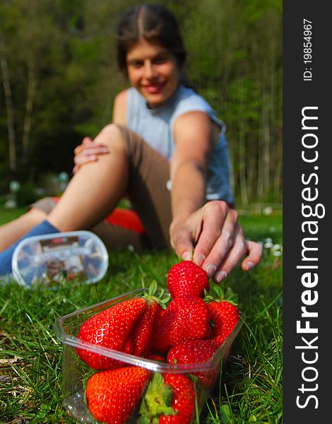 Young woman grabbing for fresh strawberry. Young woman grabbing for fresh strawberry