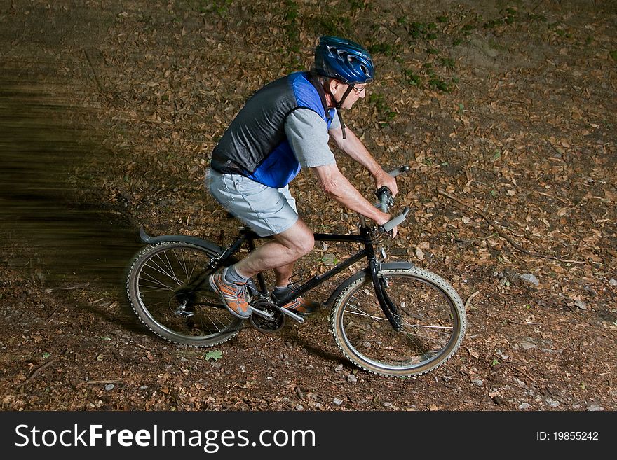 Senior cycling on a mountain bike through the forest. Senior cycling on a mountain bike through the forest