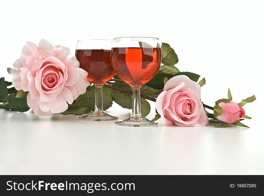 Two glasses of wine with pink roses. Two glasses of wine with pink roses