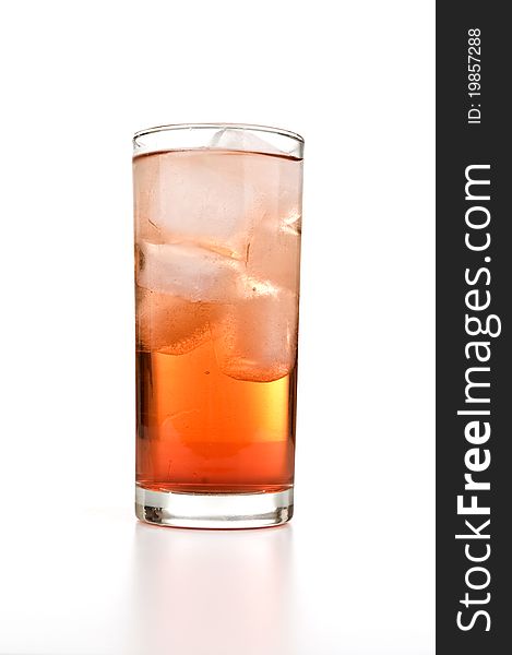 A glass filled with ice cubes and orange soda. A glass filled with ice cubes and orange soda