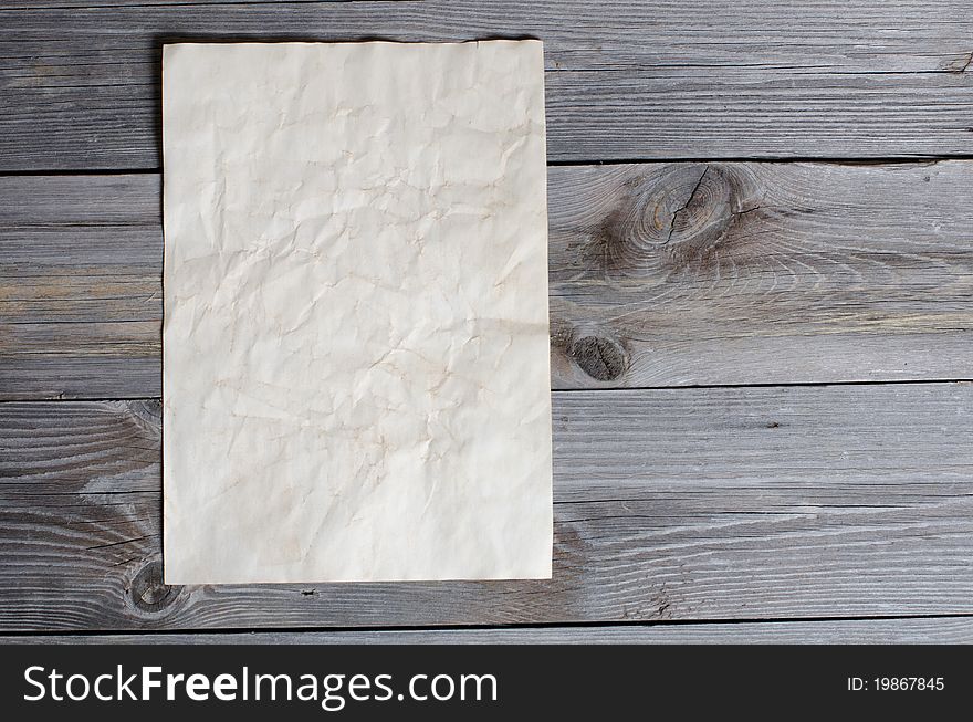 The old paper on a wooden surface. The old paper on a wooden surface