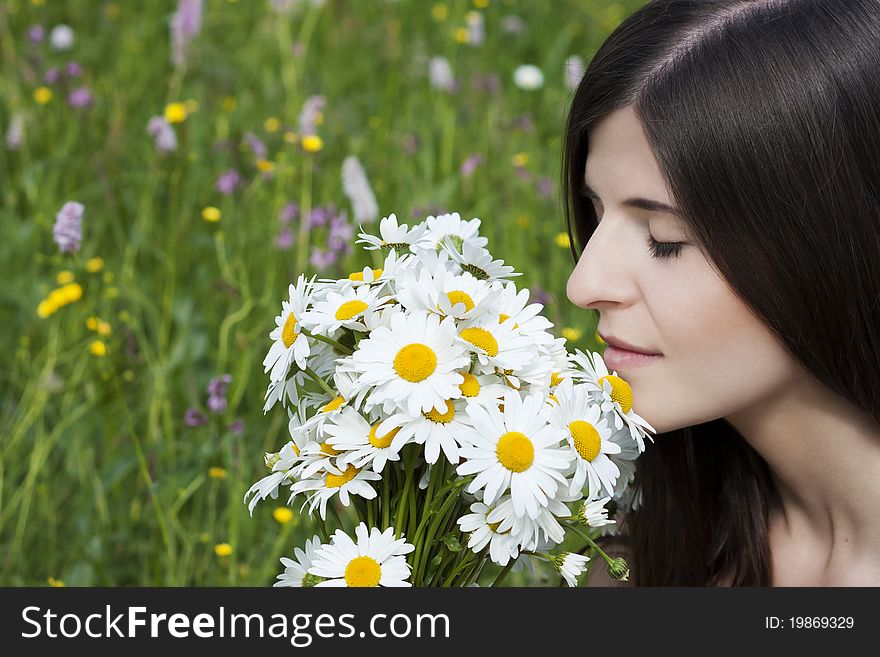 Detail of a beautiful girl smelling bunch of ox-eye daises. Detail of a beautiful girl smelling bunch of ox-eye daises