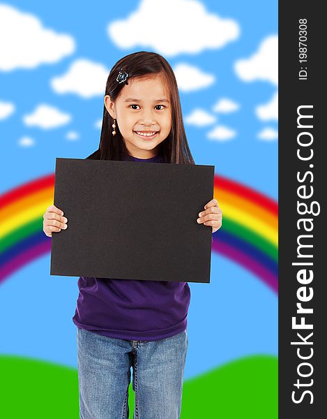 A Smiling Girl Holding A Blank Black Board With An Abstract Rainbow And Clouds Background