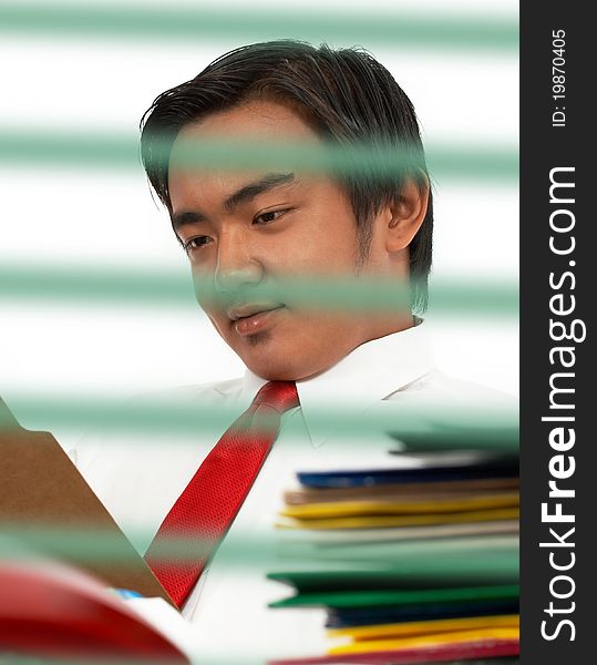 Man sitting at his office desk and reading a document in a folder. Man sitting at his office desk and reading a document in a folder