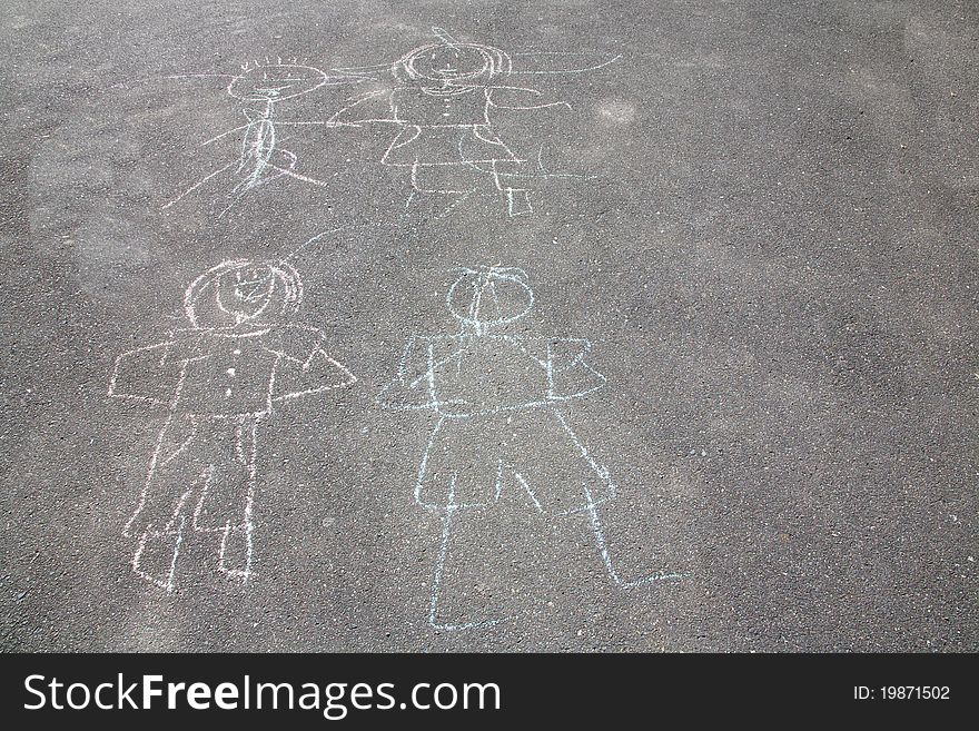 A chalk drawing of people on a sidewalk done by children. A chalk drawing of people on a sidewalk done by children