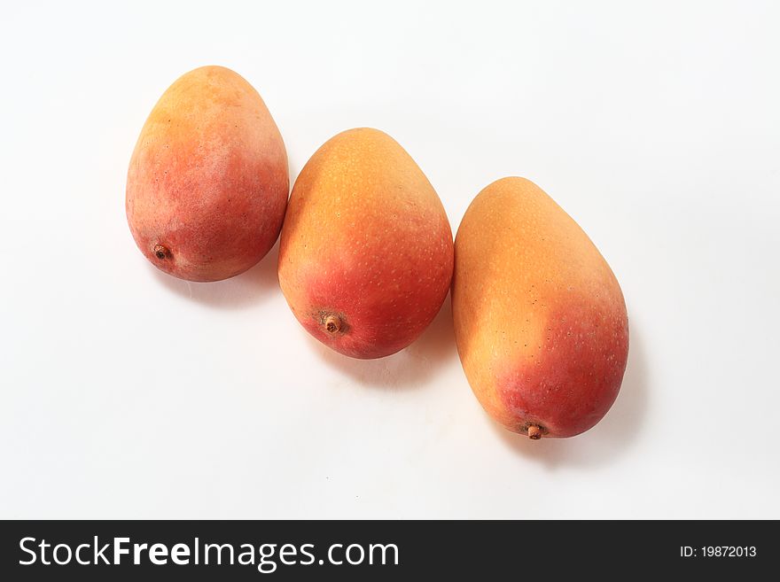 Three gold on a white background mango. Three gold on a white background mango