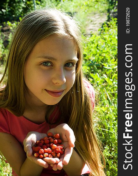 Girl with handful of wild strawberries. Girl with handful of wild strawberries