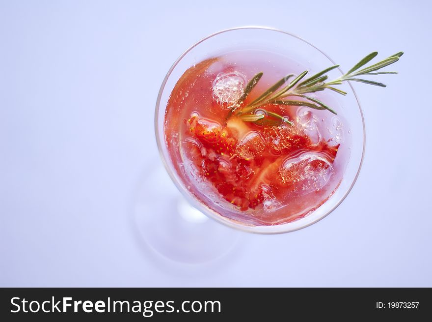 Strawberry cocktail with ice and rosemary twig